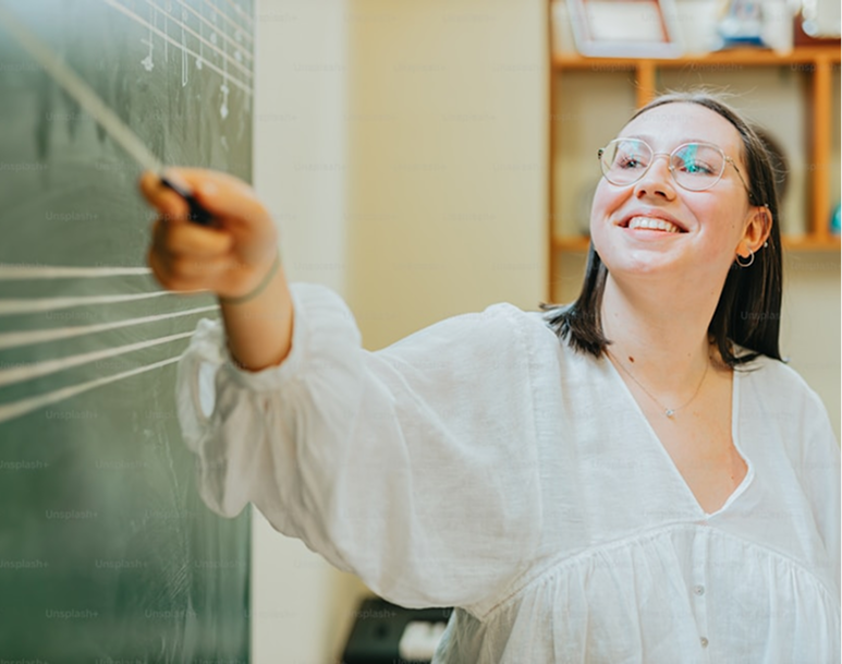 Teacher writing on whiteboard in classroom